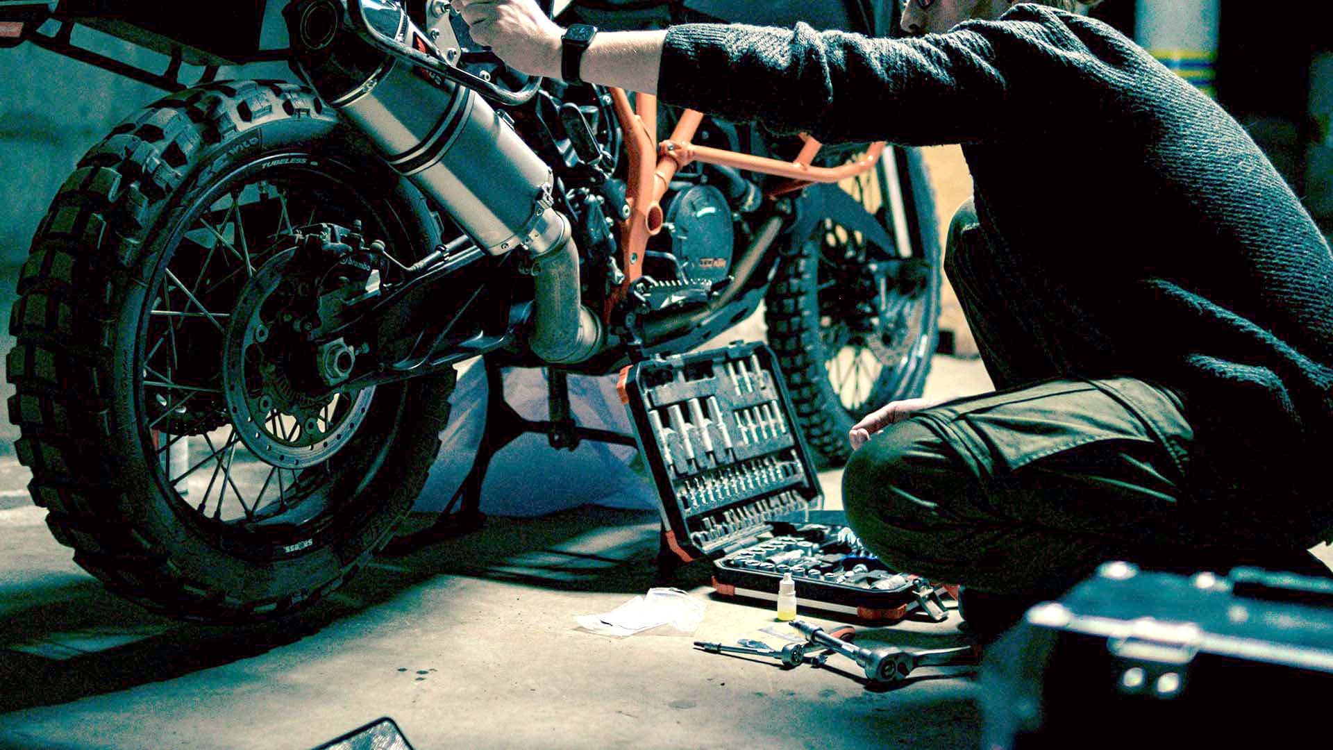 Motorcycle mechanic working on a bike in a garage
