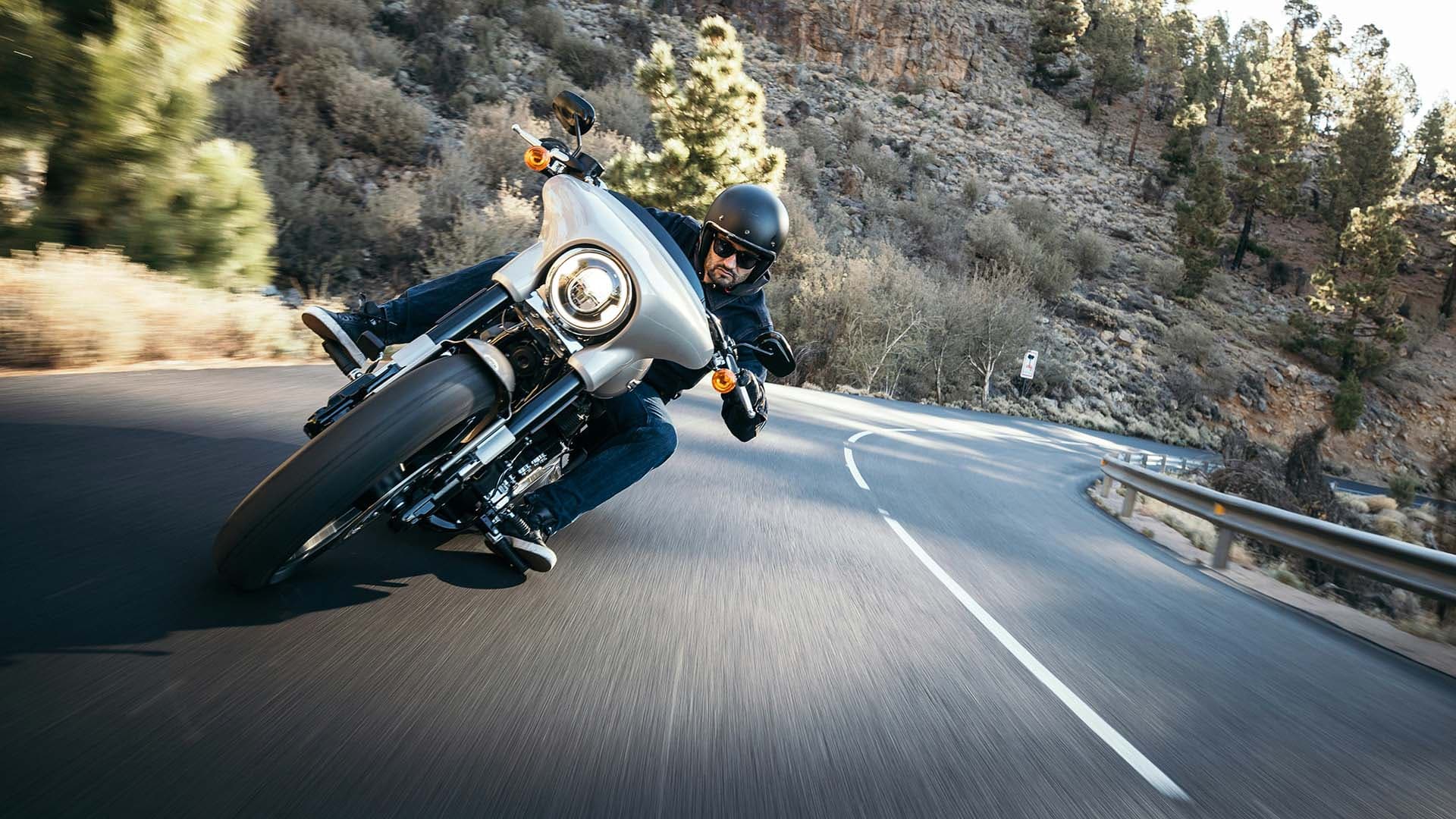 Motorcycle rider leaning into a curve on a mountain road